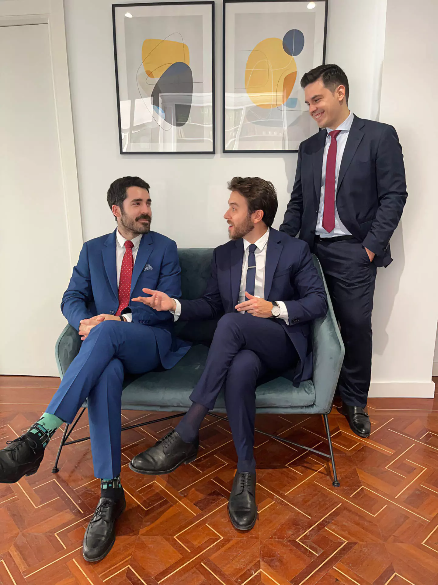 Pedro y Michel hablando sentados y Francisco mirándolos